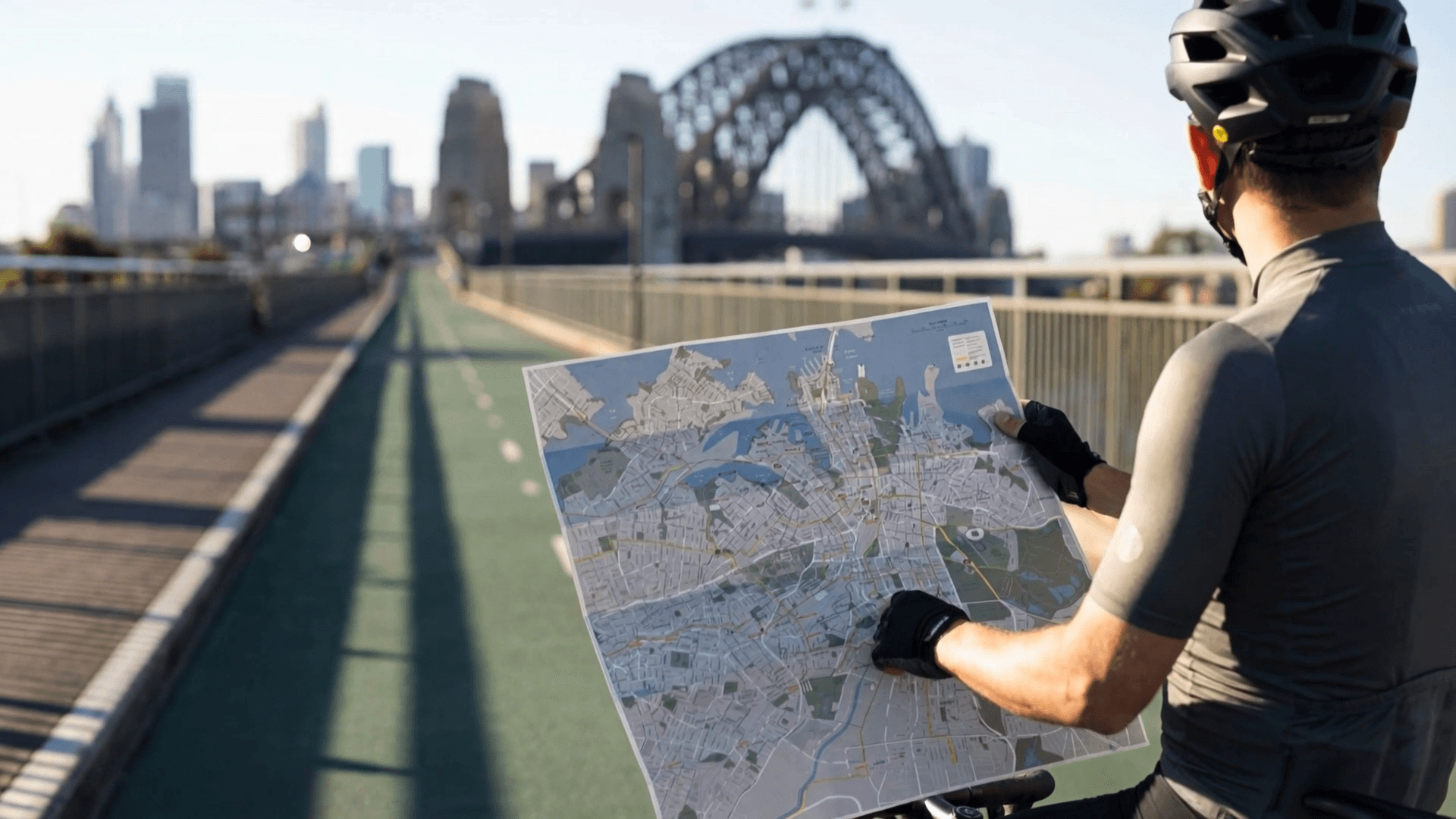 A cyclist reading an open Z-CARD city map on the Sydney Harbour Bridge